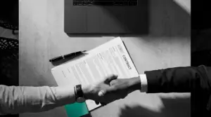 Poignée de main professionnelle au-dessus d'un contrat — comment bien choisir son prestataire pour la création d'un site de cabinet dentaire